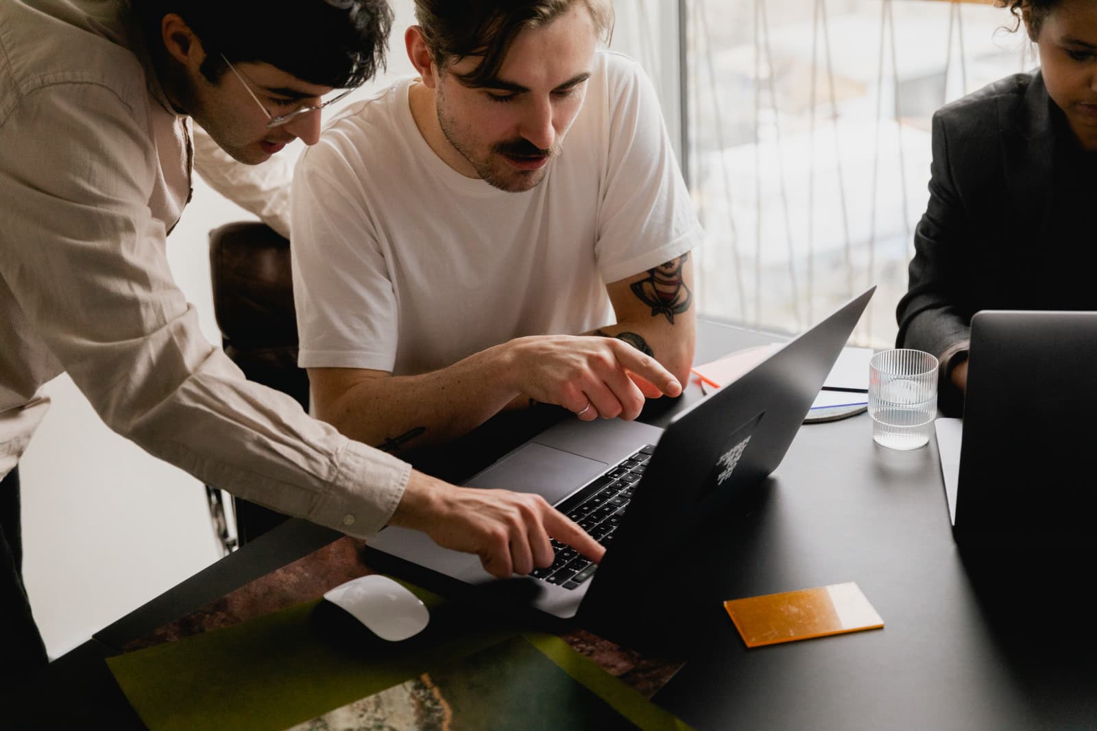 Team members reviewing performance reporting on a laptop