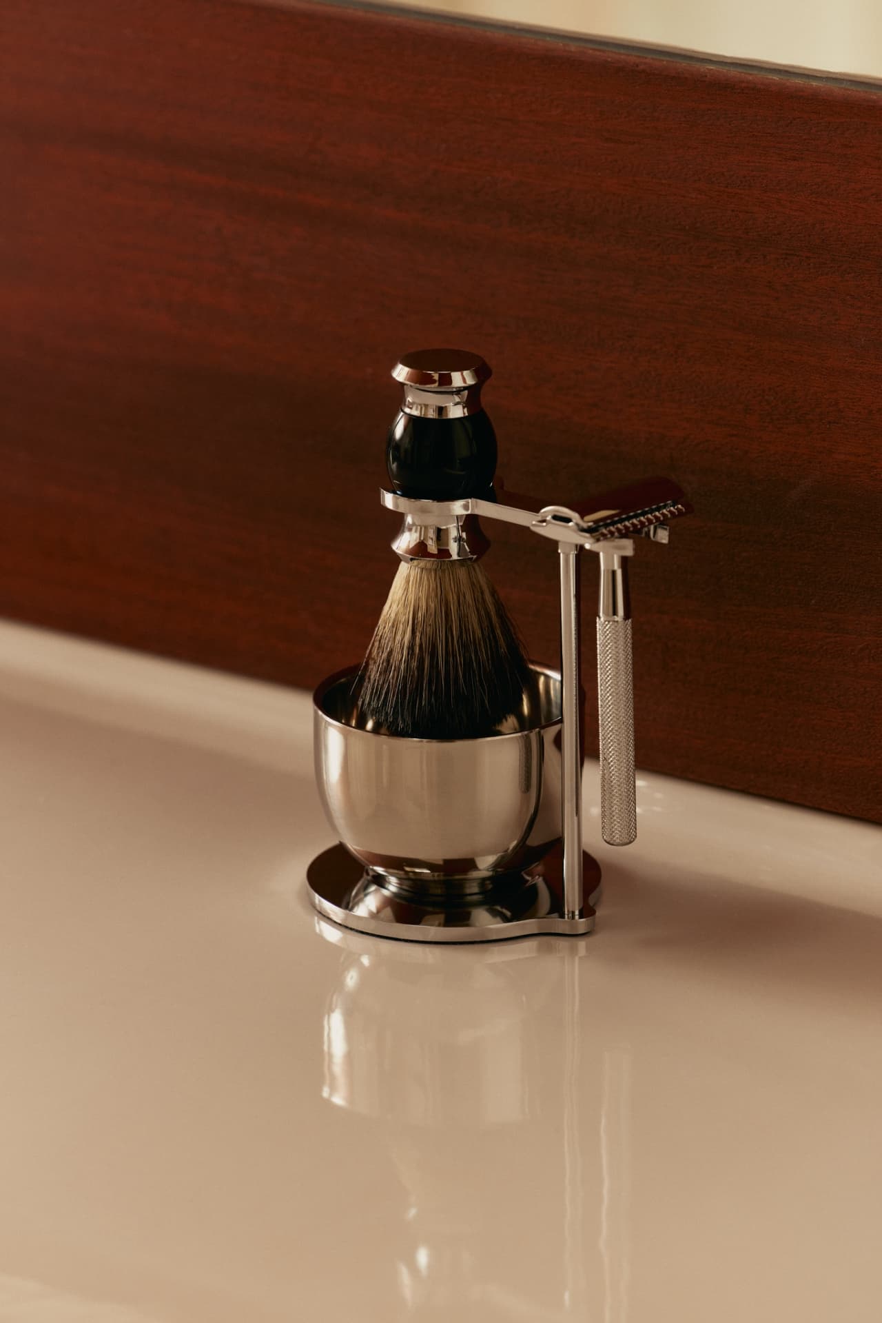 A razor, shaving brush, and bowl on a barbershop counter