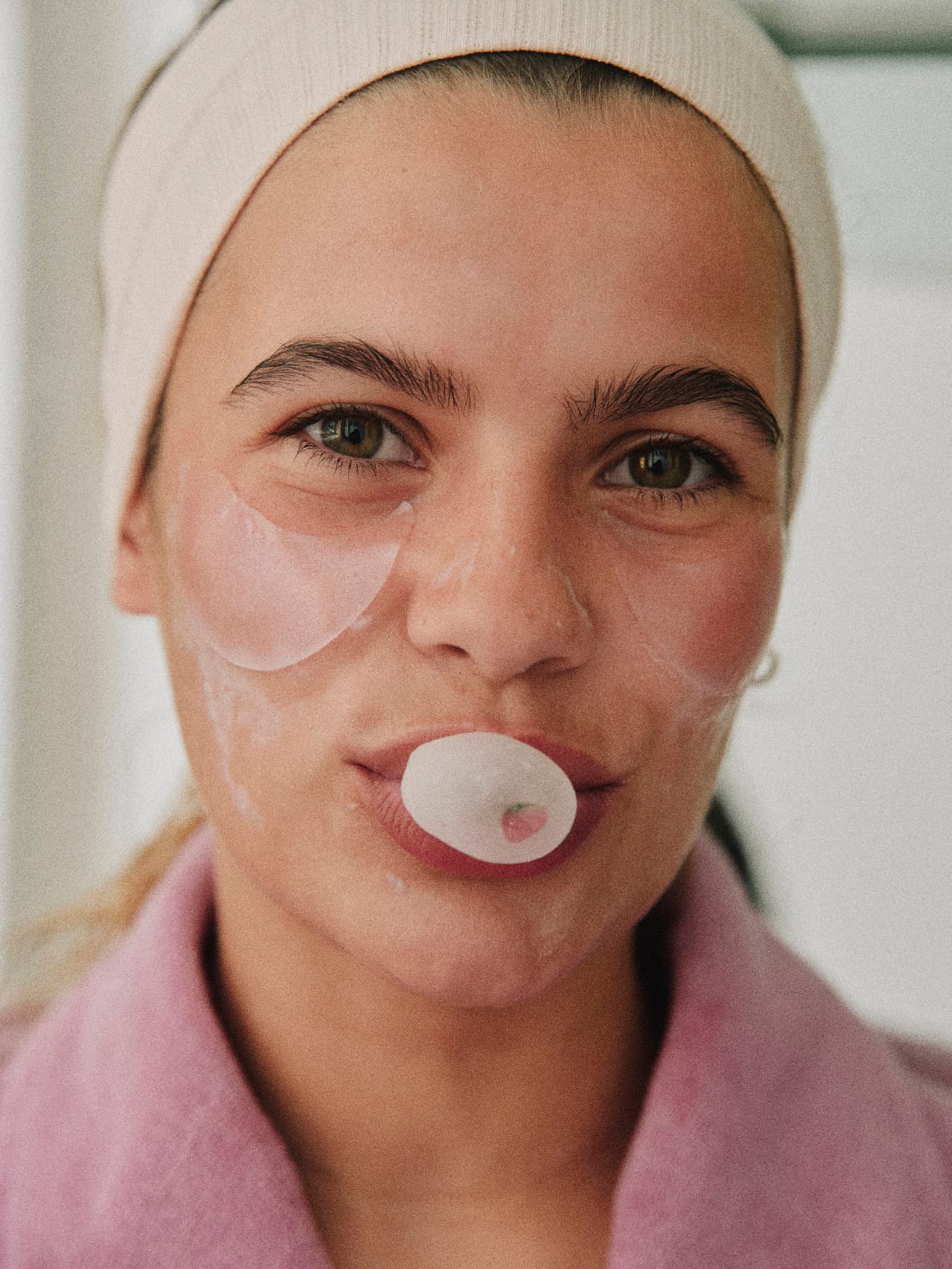 A client relaxing with under-eye and lip treatment patches applied during a skincare service