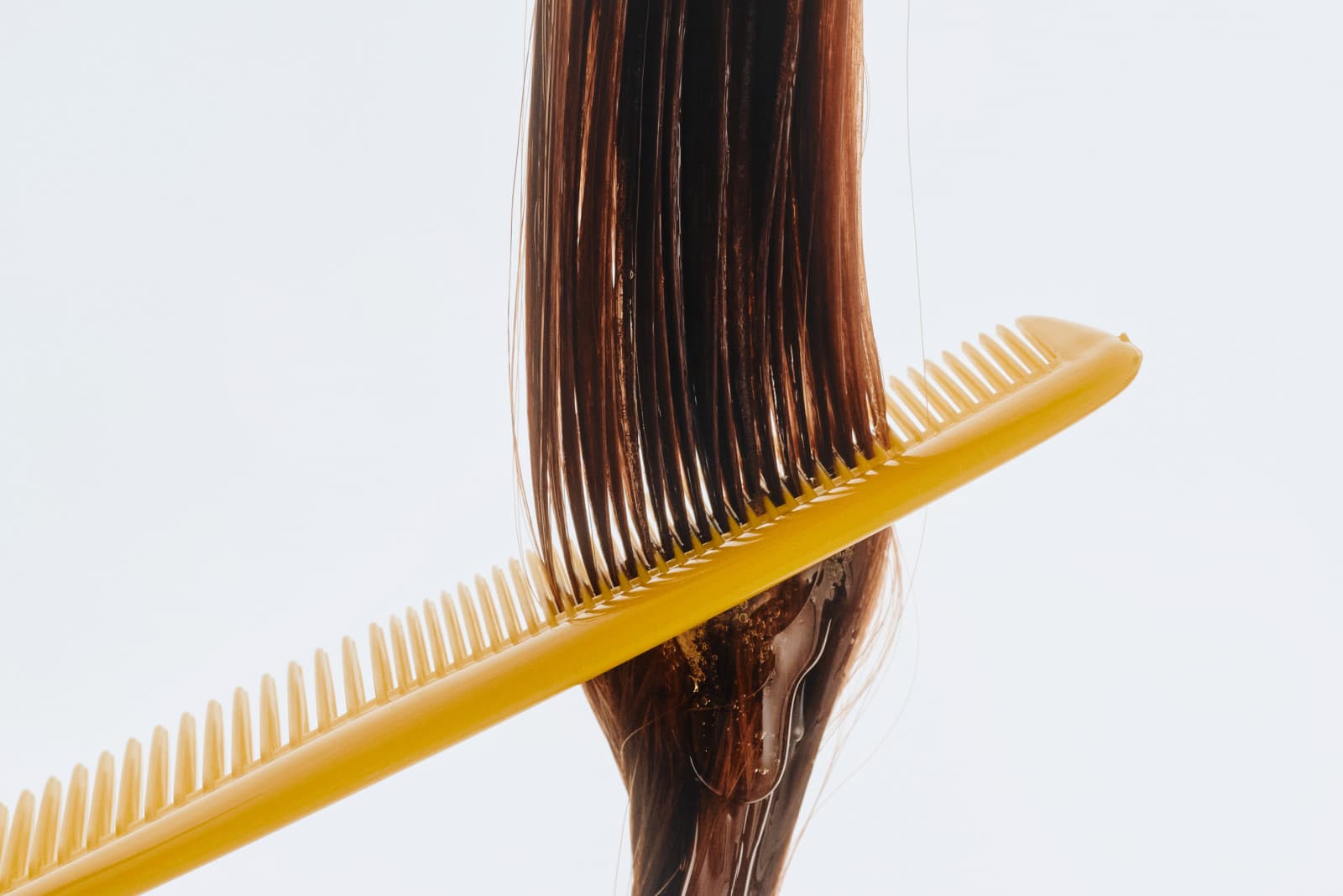 A comb pulled through freshly styled hair at Hairroin Salon
