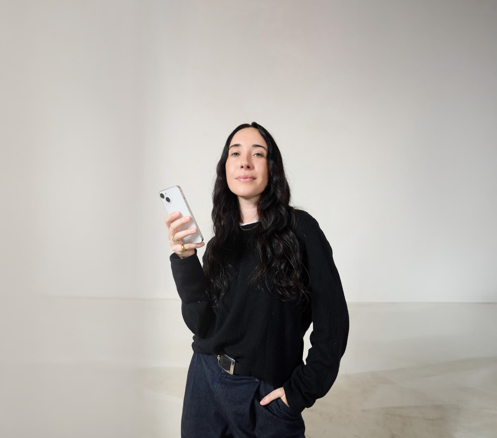 A business owner holding her phone in her studio