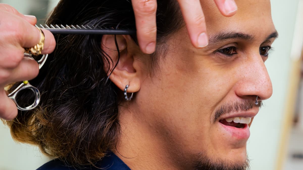 A client getting his hair trimmed by a barber.