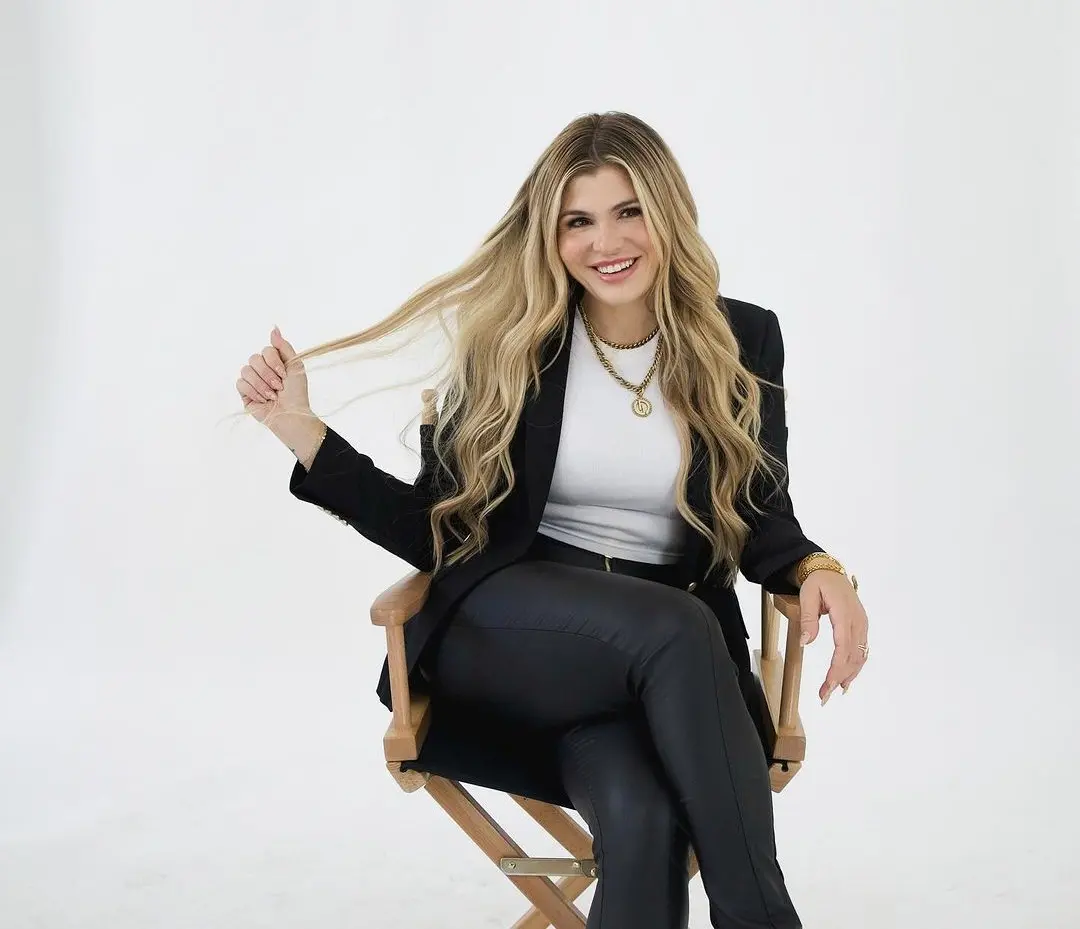 Rachel Paige smiles while sitting in a canvas chair.