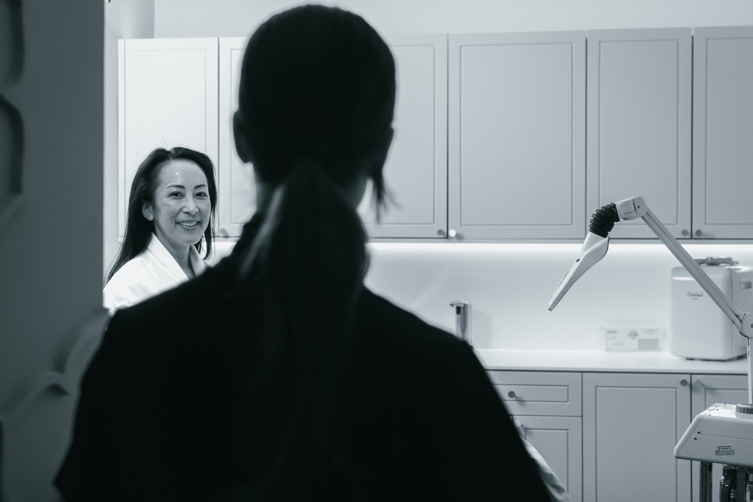 A client is walking into a room for a service, the provider is facing with their back to the screen.