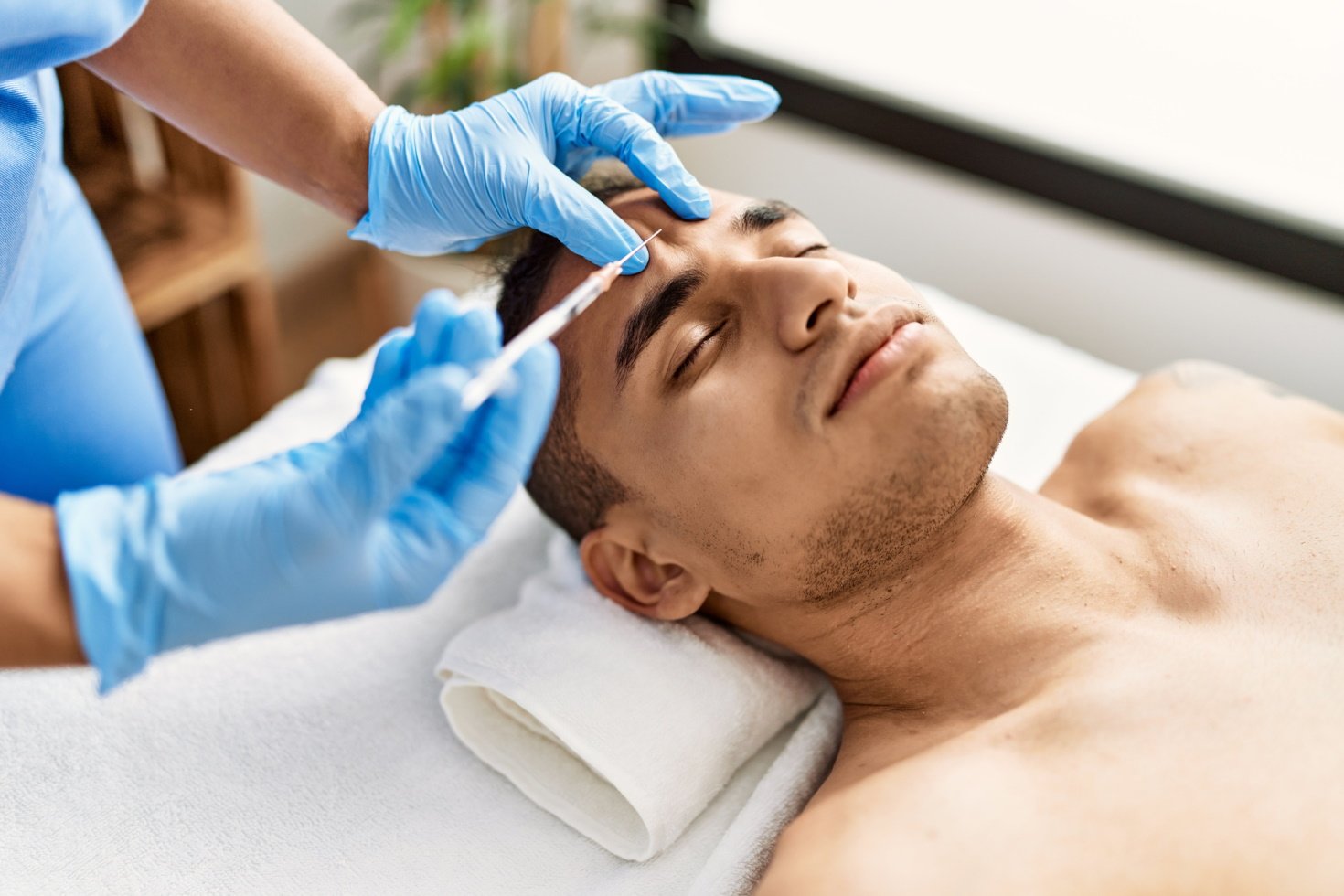 A doctor prepares to administer an injectable facial treatment to a patient at a MedSpa.