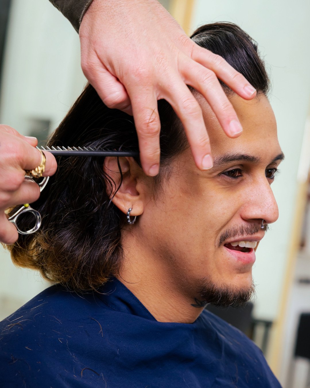 A client getting his hair trimmed by a barber.