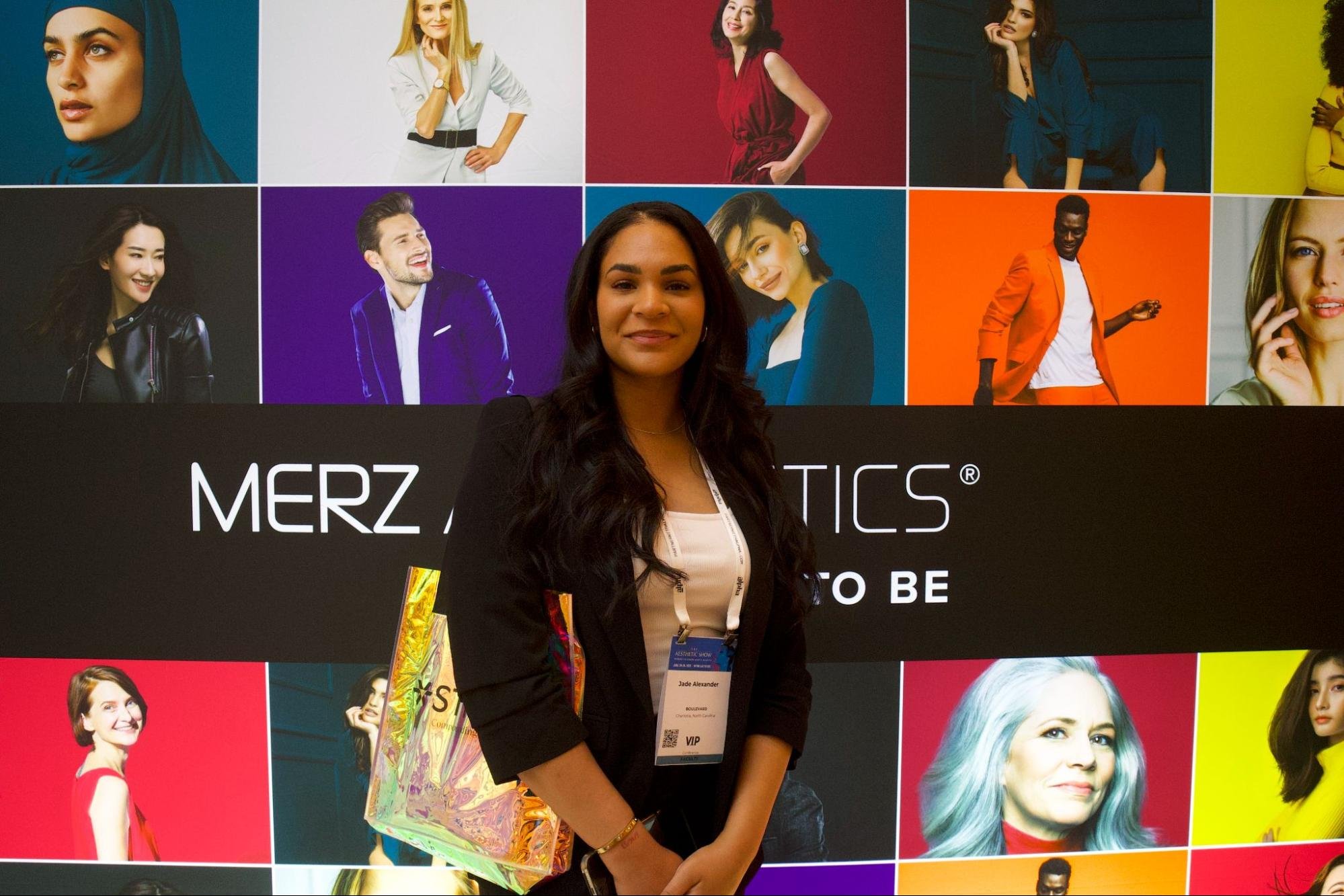 Jade Alexander standing in front of a photo grid at The Aesthetics Show in Las Vegas.