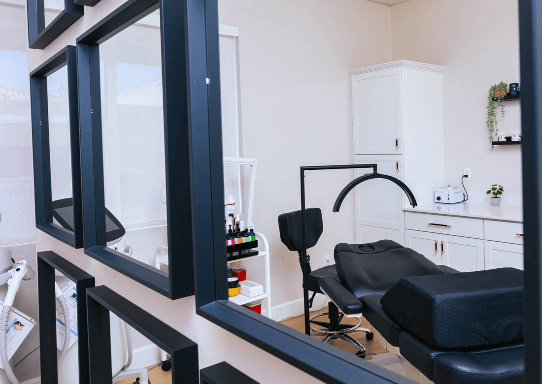 A medspa patient char as seen through the reflection of mirrors hanging on the wall.