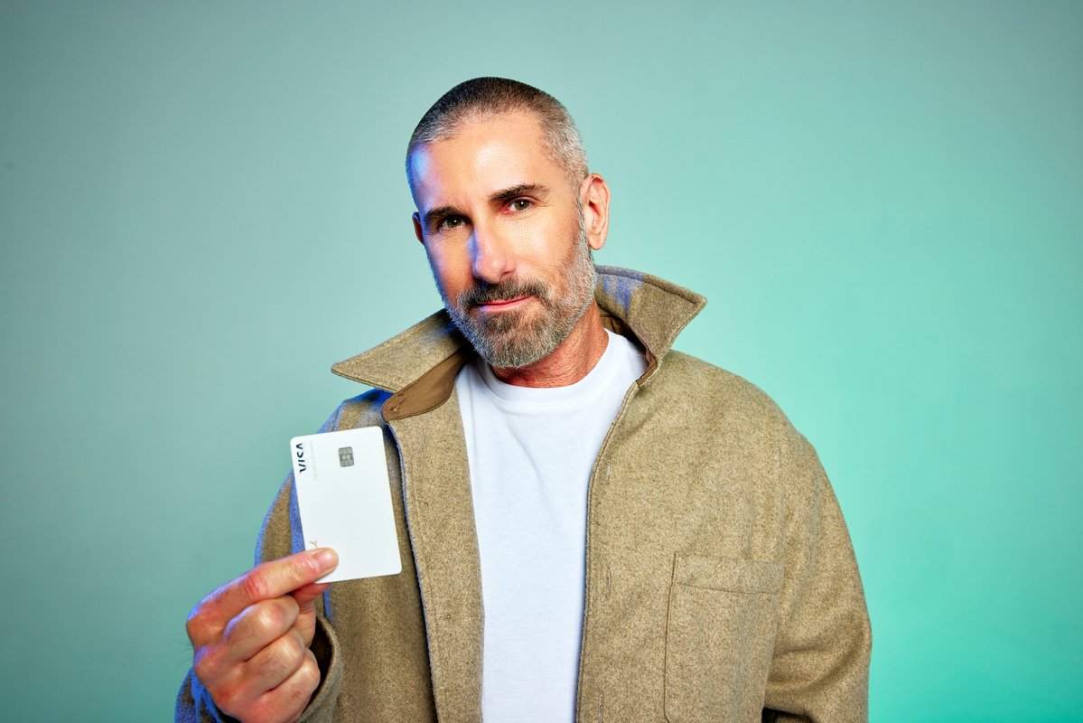 A man holding a credit card to pay for his self-care services.