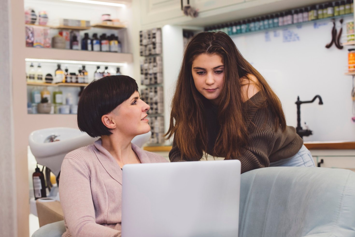 A hair salon manager meets with one of her stylists to discuss performance.