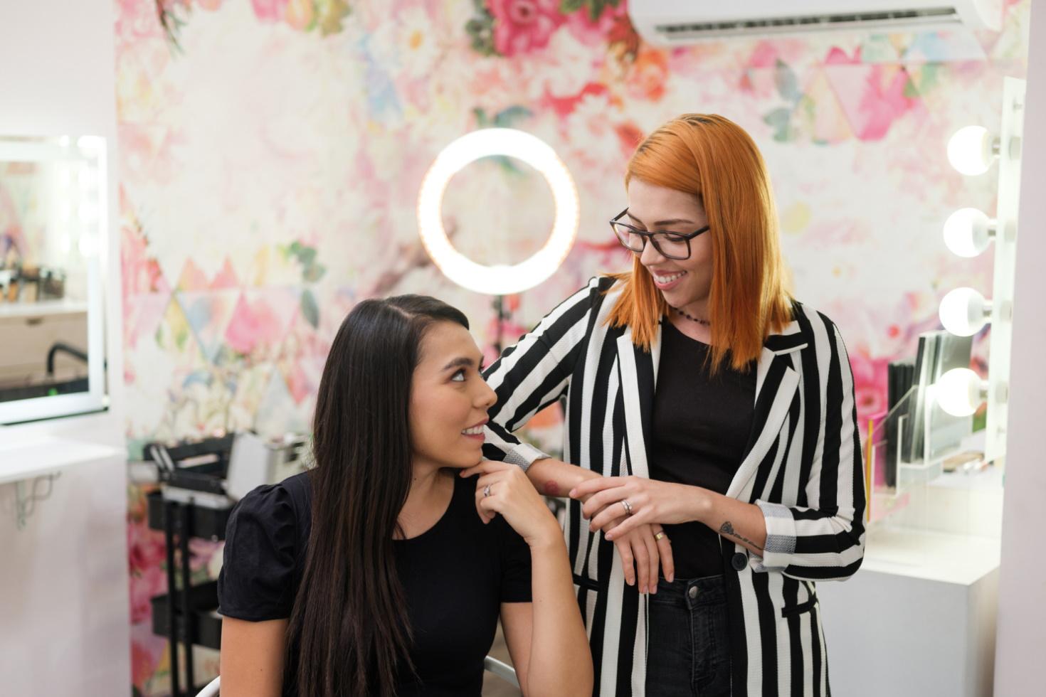 Two smiling women beauty professionals prepare for work