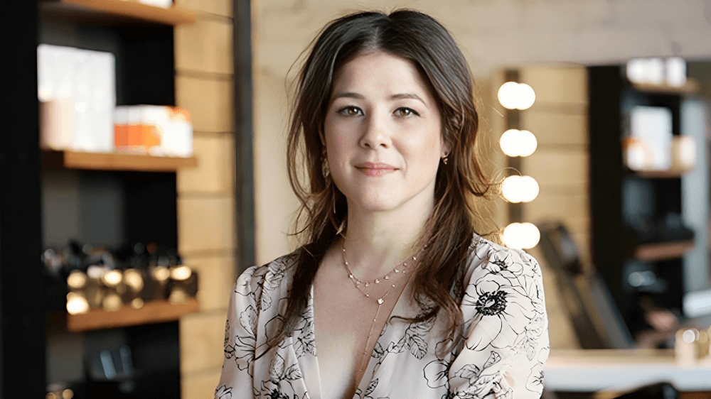 A professional photograph of stylist Tracy Cunningham sitting in a salon.