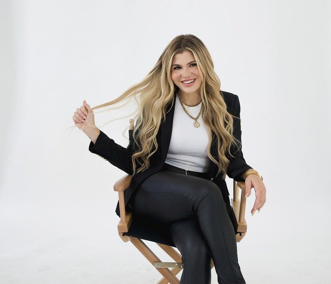 Rachel Paige smiles while sitting in a canvas chair.