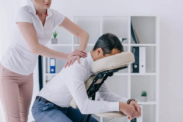 Man seated in massage chair receiving a back massage.