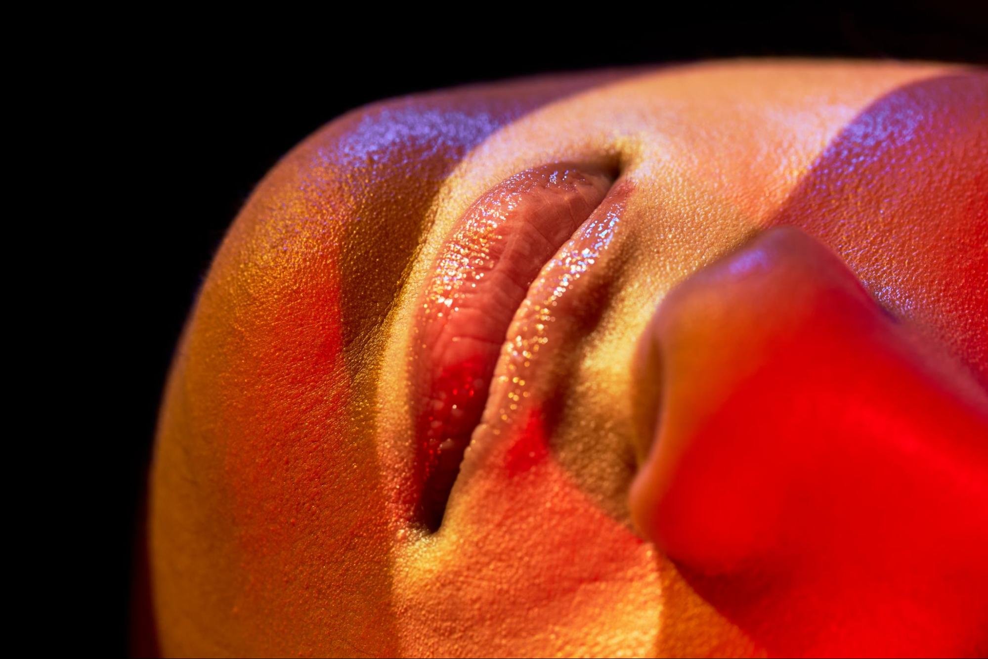 Close-up of a person's mouth and nose with bands of light playing across their face. They are laying sideways and their eyes are not visible in frame.